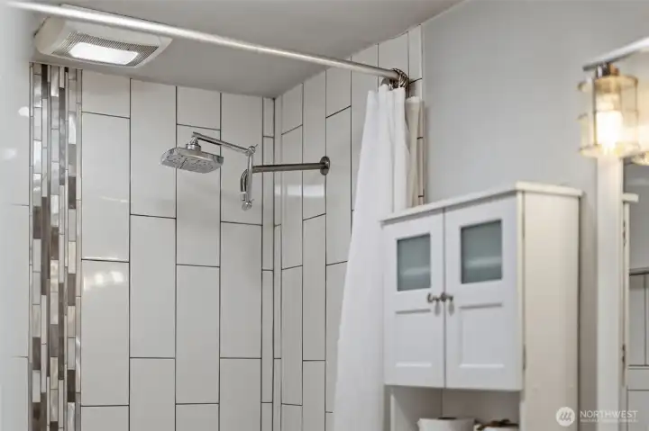 Updated bathroom with tiled shower, modern fixtures, and clean finishes.