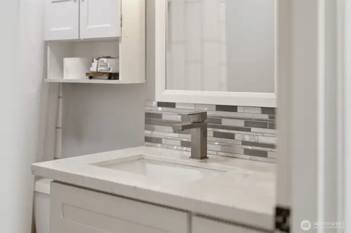 Vanity with updated lighting, contemporary design, and storage.