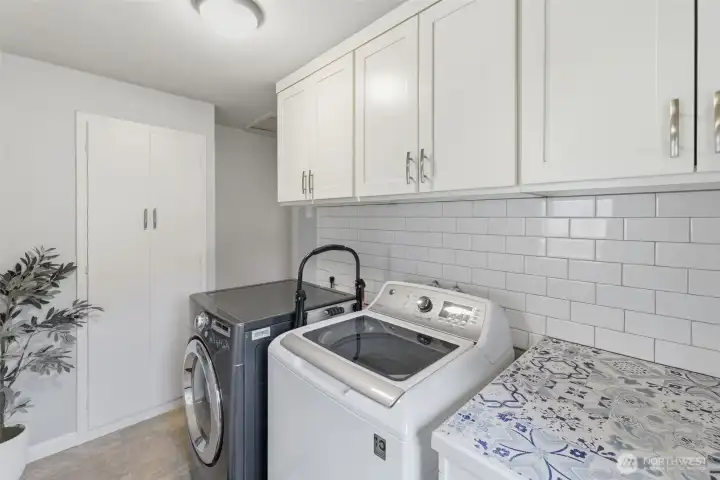 Dedicated laundry area with utility sink, cabinetry, and added storage for everyday convenience.