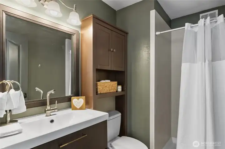 Primary 3/4 bath, modern vanity, tile shower.