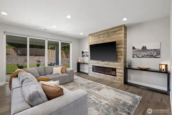 Designed for gathering and everyday comfort, the great room features large sliding doors to the covered patio and backyard, anchored by an upgraded electric fireplace with a custom shiplap surround that adds warmth and character to the space. Designed for gathering and everyday comfort, the great room features large sliding doors to the covered patio and backyard, anchored by an upgraded electric fireplace with a custom shiplap surround that adds warmth and character to the space.
