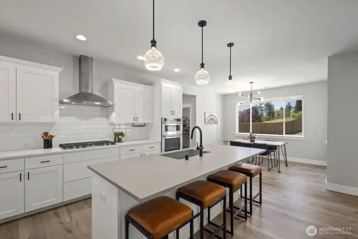 Designed with gathering in mind, the kitchen offers an oversized island, walk-in pantry, and adjacent dining area with backyard views, creating a layout that feels both open and practical. Designed with gathering in mind, the kitchen offers an oversized island, walk-in pantry, and adjacent dining area with backyard views, creating a layout that feels both open and practical.