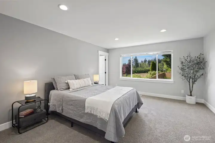 The spacious primary suite offers room to truly unwind, with oversized windows bringing in natural light and views of the private backyard setting. The spacious primary suite offers room to truly unwind, with oversized windows bringing in natural light and views of the private backyard setting.