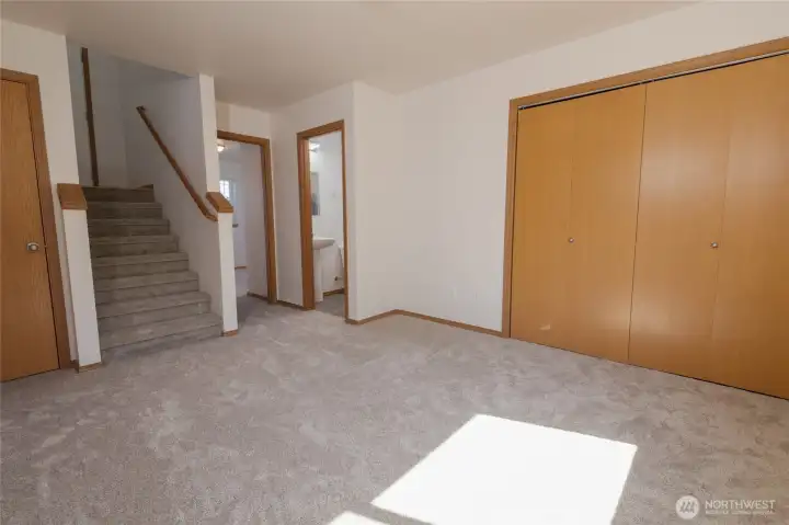 Same Family room not staged, showing laundry room closets and door to bathroom and bedroom.