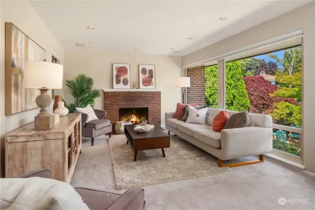 This formal living room features a masonry fireplace and floor-to-ceiling insulated windows.