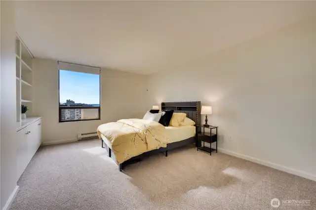 Spacious guest bedroom with custom built-in shelving & cabinetry also with a westerly view.