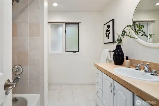Light colors and a window for natural light give this main bath an open and inviting feel.