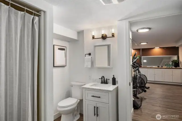 The basement features a walk-through three-quarter bath, with two doors for privacy, with new vanity, sink and toilet. Adjacent is a versatile room, ideal for a home gym, offering privacy and convenience for your fitness routine. Having a bathroom nearby adds to the practicality of this workout space, making it easier to freshen up post-exercise.