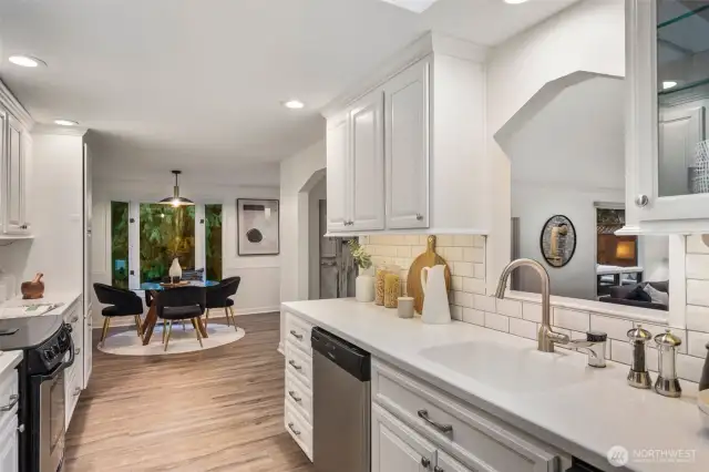 The kitchen offers both style and function with a spacious sink, elegant swan neck faucet, and a convenient cutout window to the living room—perfect for staying connected while preparing meals.