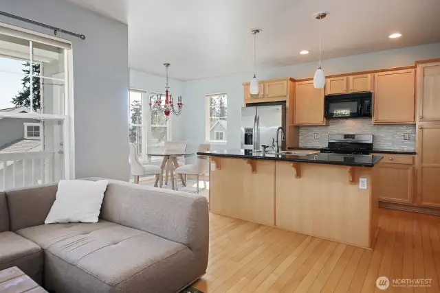 Open concept kitchen/dining/living. There is plenty of space at the kitchen island for stools. Microwave above propane stove top/range.