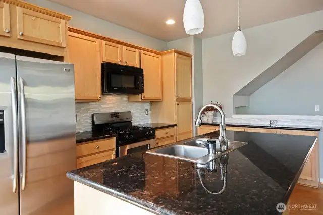Insta-hot water at the sink, a convenience you will appreciate. Note, there is additional cabinetry and counter space along the open wall to the stairwell.