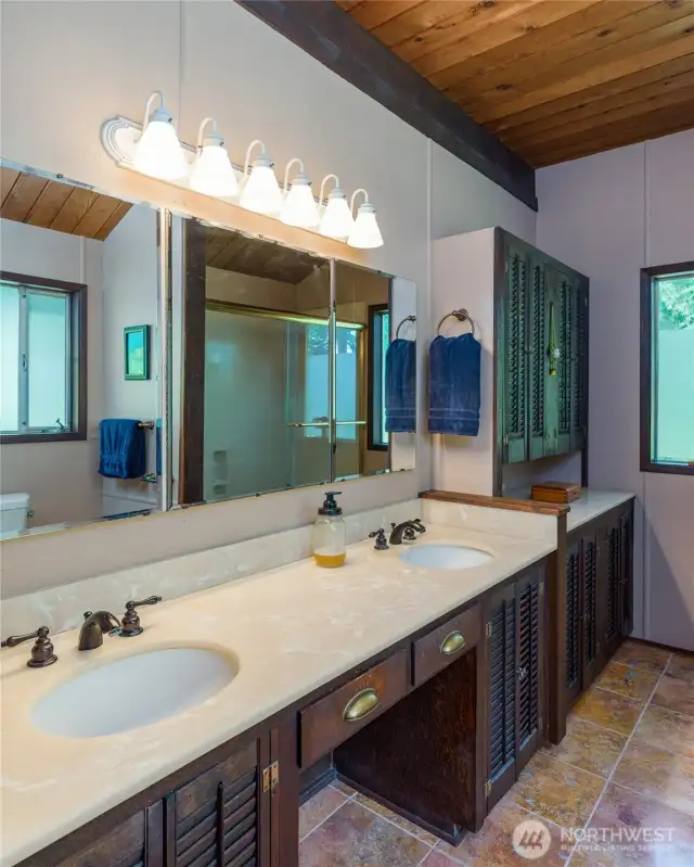 Primary bathroom with double sinks and the tub/shower reflected in the mirror.