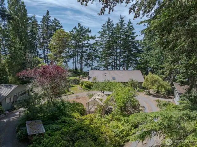 Good view showing the relationship of the buildings---shop right, home middle and garage left, all on a circular driveway.