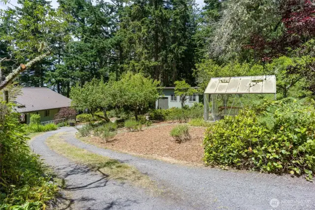 Building to the left of the greenhouse is the shop.