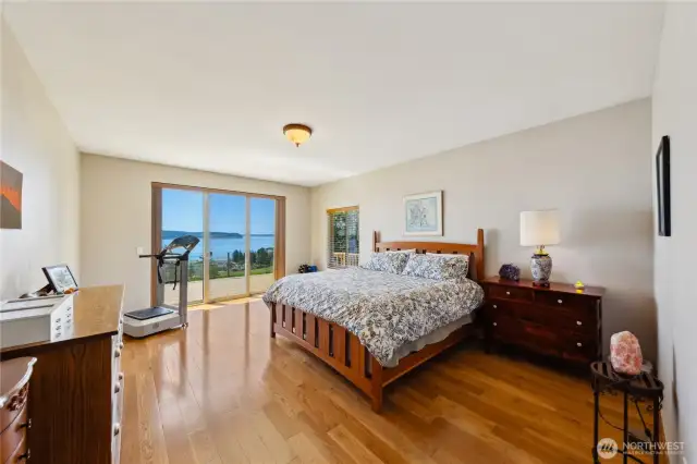 This is the Primary Bedroom with a 3-panel slider to the wrap around deck.  There is a ensuite bathroom with walk-in closet between the bedroom and bathroom.