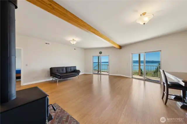 This is the lower-level Great Room.  Twin sliders open the lower-level deck and hot tub.  Lots of open space, a wood burning stove and a full kitchen/bar behind the stove. That's a second guest bedroom through the door on the lelft.