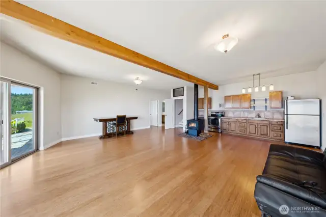 Here is the Full kitchen/Bar area.  There's an Oven, Fridge, and Sink.  You can see that white open door on the far left is the Bonus Room.  Right next to the white open door is the lower-level bathroom.   Those stairs lead up tot he main level.