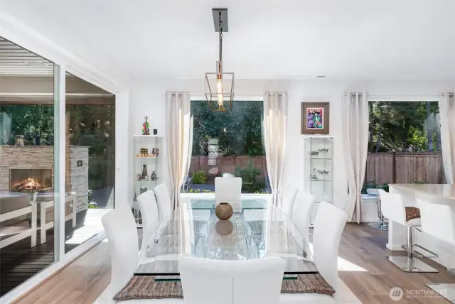 Dining area is bathed in natural light, surrounded by large windows from every direction—offering serene views and a bright, airy atmosphere.