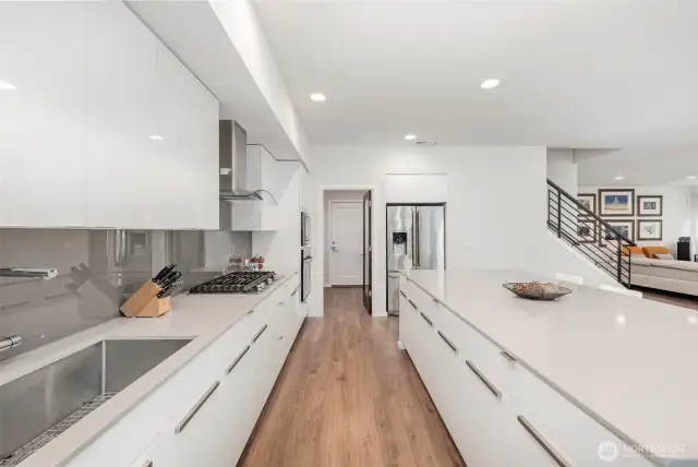 This sleek and modern kitchen showcases crisp white cabinetry, stainless steel appliances, and recessed lighting—offering both style and functionality.