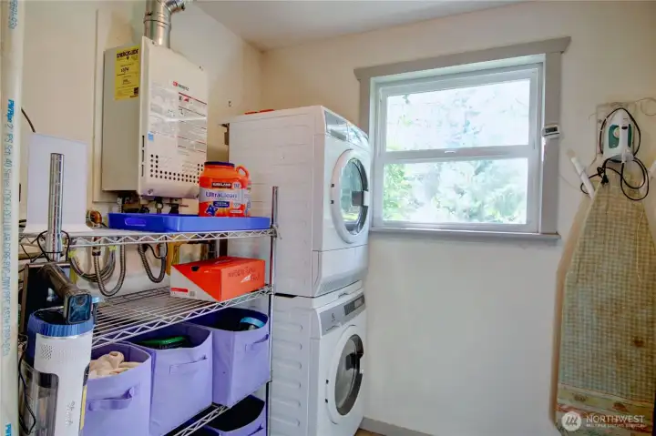 Laundry/mud room with stack washer/dryer, tankless water heater and storage.