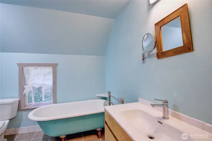 Main bathroom with a vintage clawfoot tub, shower(not in picture), sink and toilet.