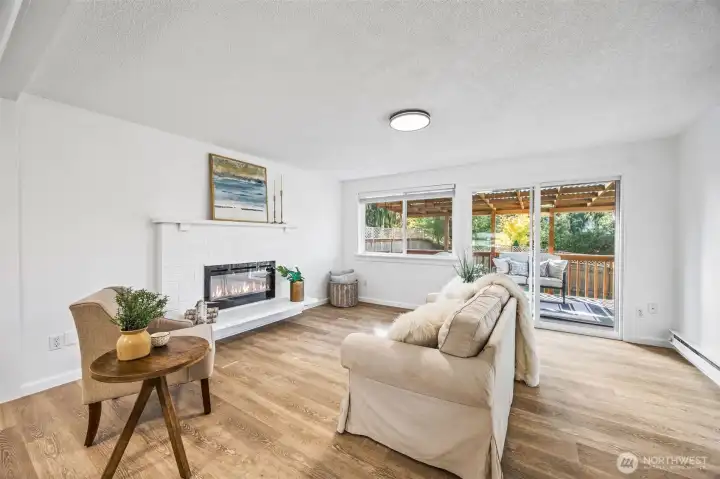 Open-concept living room with LED electric fireplace flows directly to the deck, ideal for entertaining.