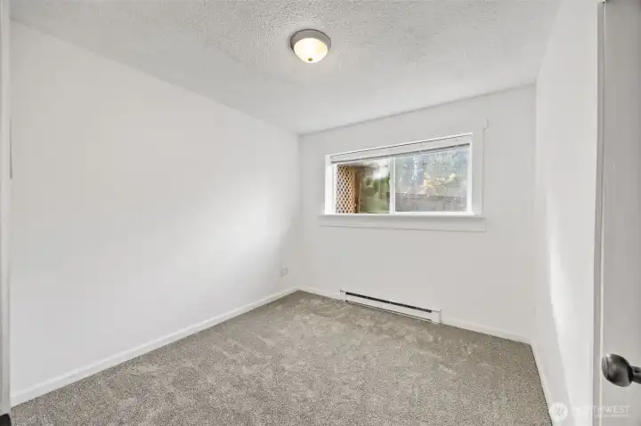 Lower-level bedroom ideal for multigenerational living or a home office, conveniently near the bathroom.