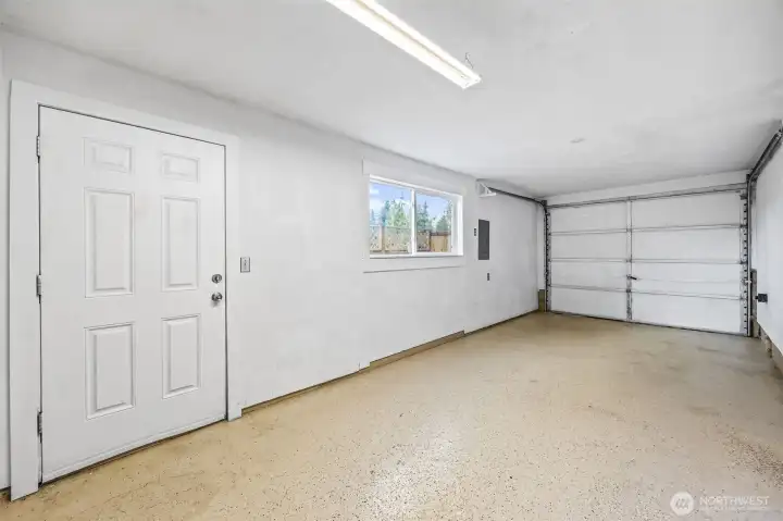 Garage fits two cars with sleek epoxy flooring.