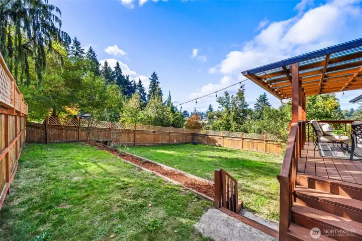Large fenced backyard with new flower beds.