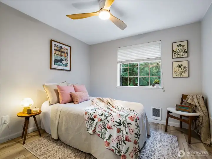 The windows in this room looks out to the wooded backyard