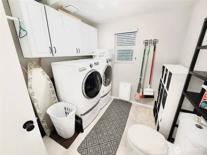 Downstairs half bath with laundry and extra storage cabinets