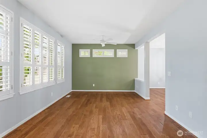 Great room with engineered hardwood floors featuring a gas fireplace, transom and shuttered windows. Great room with engineered hardwood floors featuring a gas fireplace, transom and shuttered windows.