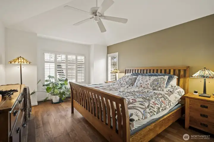 The primary suite boasts a tall vaulted ceiling with ceiling fan.