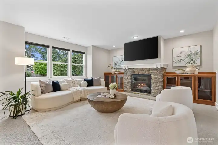 Spacious great room with gas fireplace, custom built-ins, and open-concept connection to the kitchen, designed for comfortable living and entertaining.