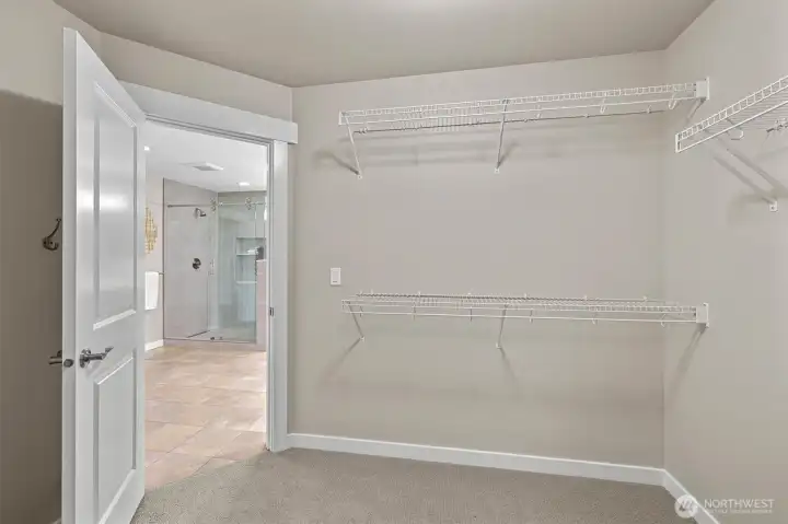 Spacious walk-in closet with built-in organization, offering ample storage and easy access from the primary suite.