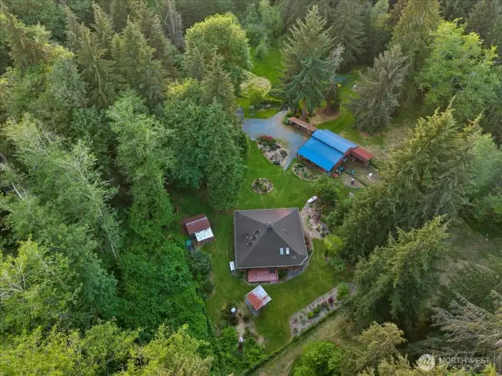 Expansive aerial view showcasing the private wooded setting, open lawn areas, and surrounding natural landscape. The property is nestled among mature trees with scenic valley views in the distance. Expansive aerial view showcasing the private wooded setting, open lawn areas, and surrounding natural landscape. The property is nestled among mature trees with scenic valley views in the distance.