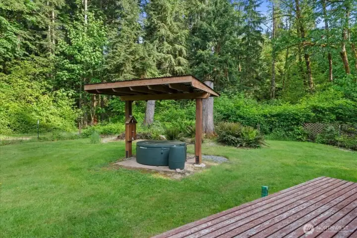 Covered hot tub area is set within a peaceful, wooded setting with surrounding lawn and landscaped greenery. Covered hot tub area is set within a peaceful, wooded setting with surrounding lawn and landscaped greenery.
