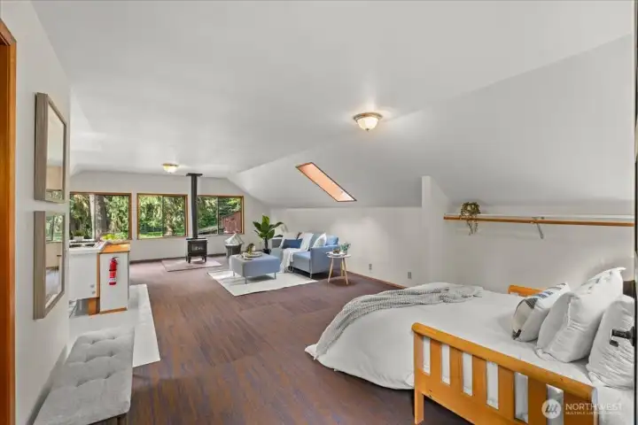 Spacious finished loft area features flexible living and sleeping space, large windows with wooded views, and a freestanding stove for added comfort. Spacious finished loft area features flexible living and sleeping space, large windows with wooded views, and a freestanding stove for added comfort.