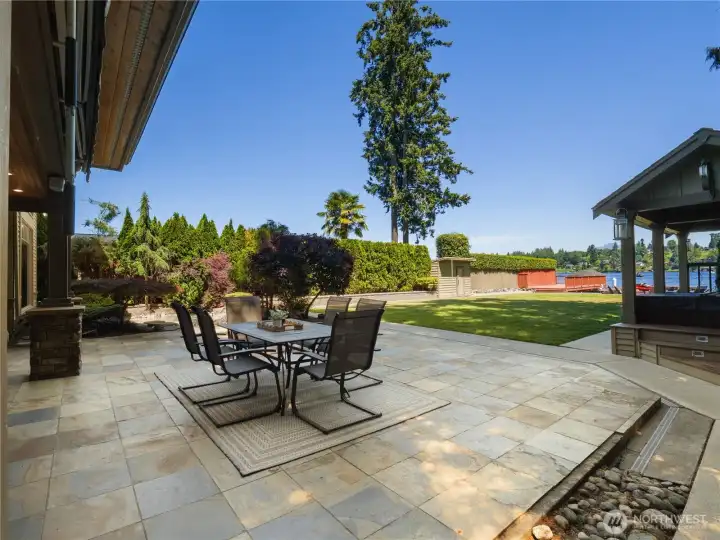 Designed for effortless indoor-outdoor living, this waterfront property features an expansive stone patio that extends into beautifully maintained grounds overlooking the lake. Designed for effortless indoor-outdoor living, this waterfront property features an expansive stone patio that extends into beautifully maintained grounds overlooking the lake.