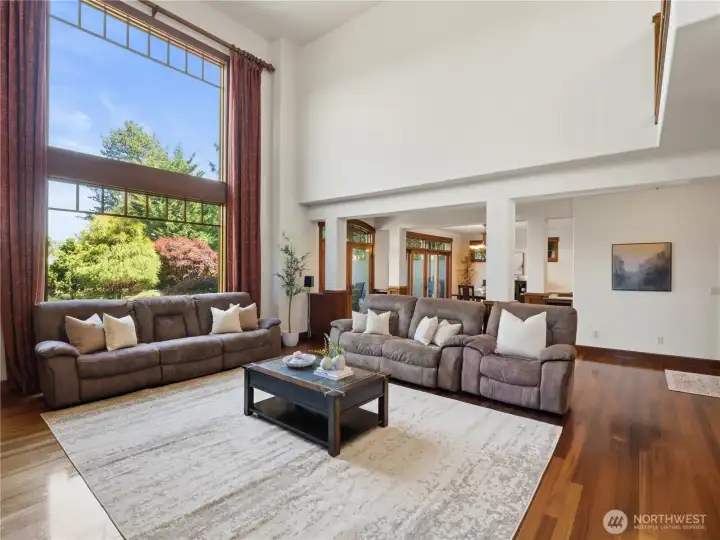 Dramatic ceiling heights and expansive windows define this spacious great room, filling the space with natural light and showcasing beautiful outdoor views. Dramatic ceiling heights and expansive windows define this spacious great room, filling the space with natural light and showcasing beautiful outdoor views.