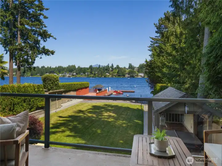 The primary suite's private balcony offers a peaceful outdoor escape with expansive views of the lake, shoreline, and beautifully maintained grounds below. Whether enjoying a morning beverage or unwinding at the end of the day, this inviting space provides a scenic vantage point and seamless access to the outdoors. The primary suite's private balcony offers a peaceful outdoor escape with expansive views of the lake, shoreline, and beautifully maintained grounds below. Whether enjoying a morning beverage or unwinding at the end of the day, this inviting space provides a scenic vantage point and seamless access to the outdoors.