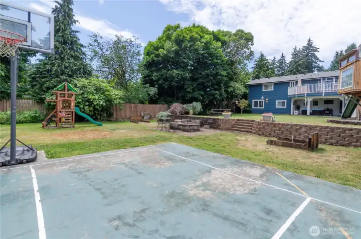 Check out this huge fenced back yard.  Full sized sports court, play areas, firepit and covered back patio.