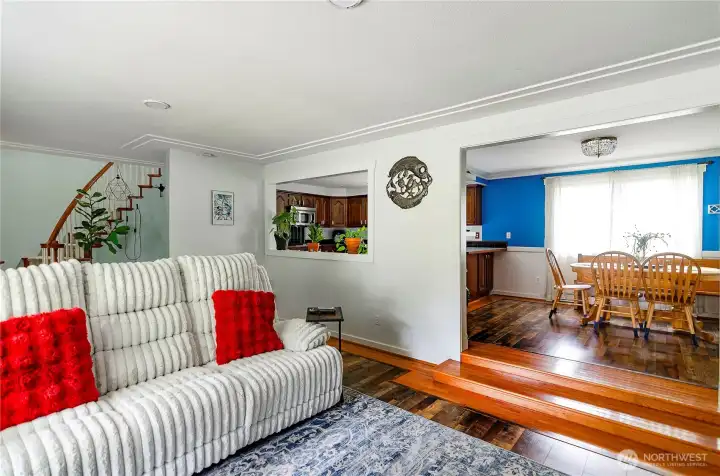 Another view of the living room showing dining room and open window looks into the kitchen.