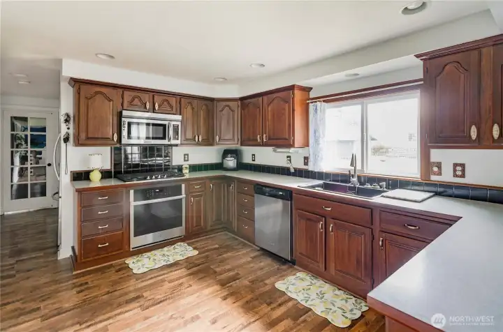 Newer stainless appliances. The full size refrigerator is conveniently located around the corner , which allows for more storage and better flow.  Walk-in pantry on the opposite side of hallway.