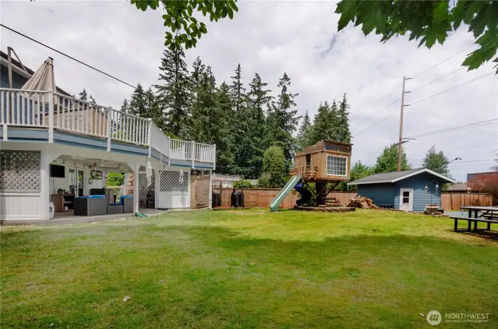 This back yard has so much to offer.  Tree house, picnic area, shop with roll up door and sports court.  Also open patio grilling station