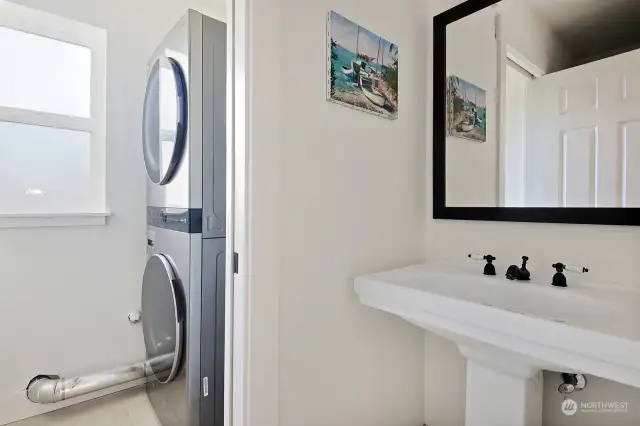 Half bath with washer & dryer beyond. There is a pocket door between the 1/2 bath and washer & dryer. Ceramic tiled floors.