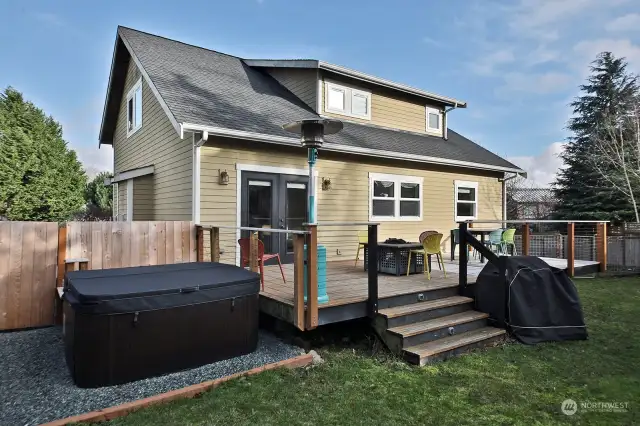 Current owners expanded the deck and added the hot tub. Fenced area beyond the hot tub is the perfect place to store your kayaks. Dormers on the second level provide extra light and a sense of spaciousness.  French doors lead to your open dining/living room.