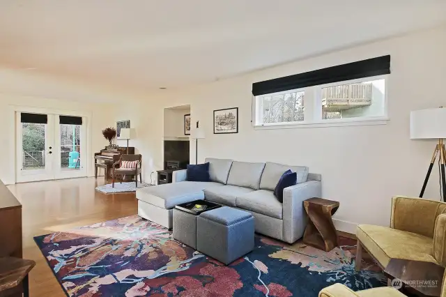 Your back is to the front door. The dining area and kitchen are around the corner to your left. The French doors lead to your back deck. Note the freestanding propane fireplace/stove just beyond the sofa.