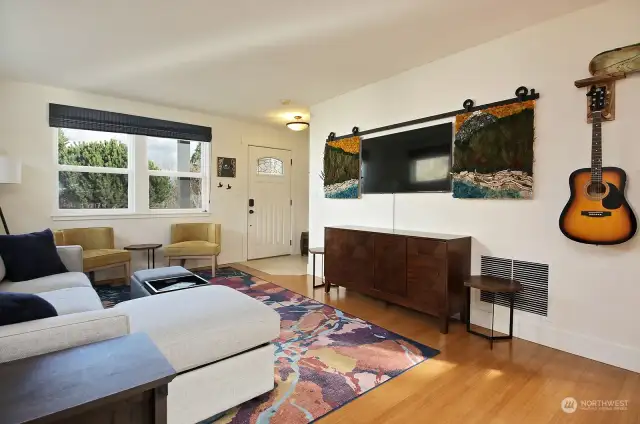 Looking back at the front door and the windows that look out upon the covered front porch.  Please note that the rolling art/television screen does NOT convey. Television conveys, however, sellers will be taking artistic cover/screen.