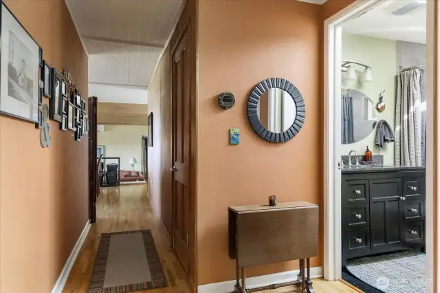 Full bath at right, then looking down the hall toward the living, dining, kitchen portion of the house.